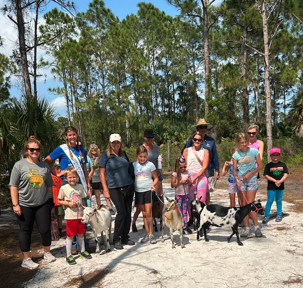 A group of people and goats on the trail at Newfield in Palm City